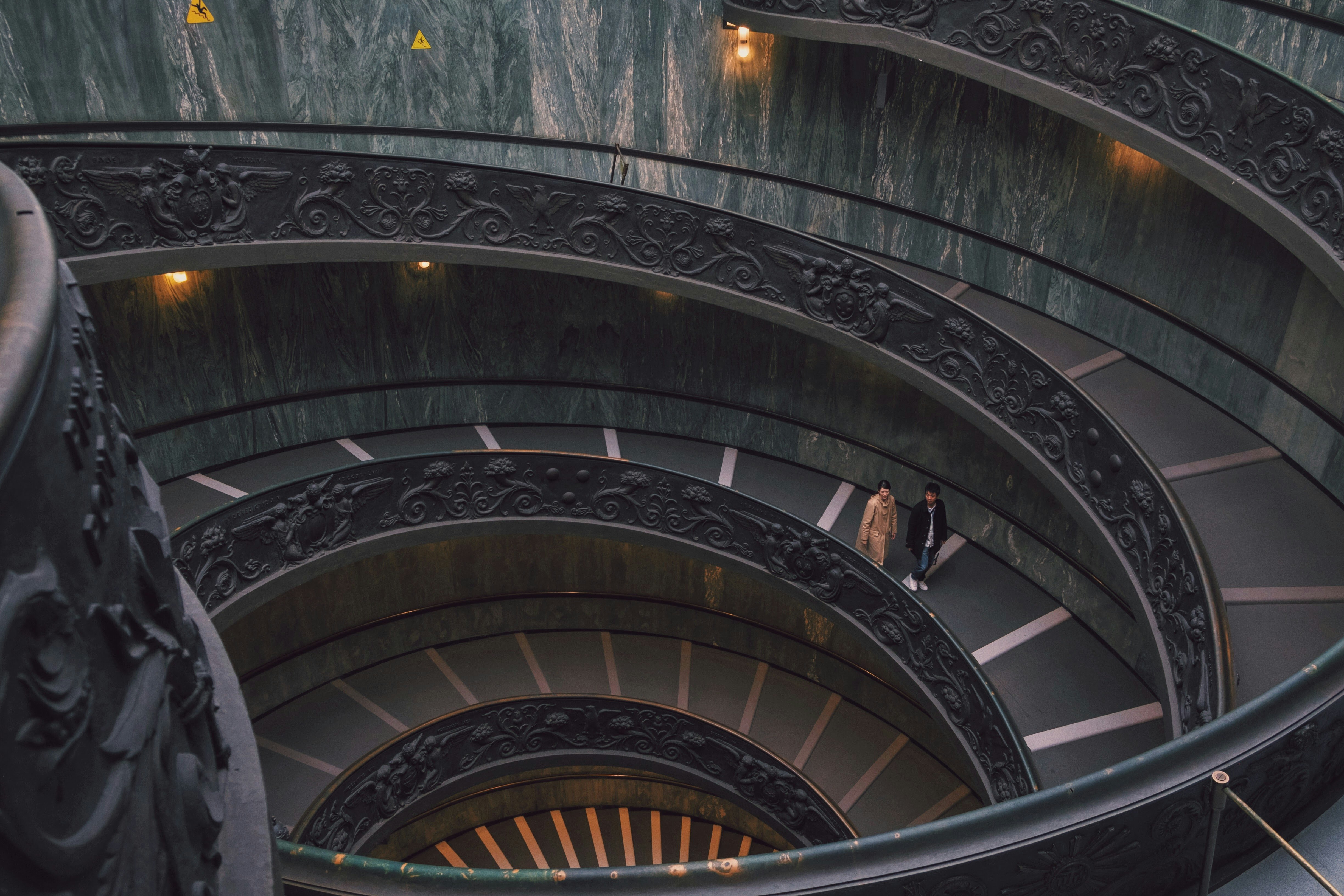 two person walking on spiral staircase